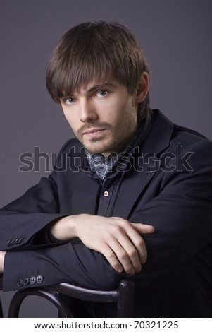 portrait of handsome man in business suit over grey background