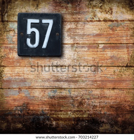 Number 57 on a wooden background