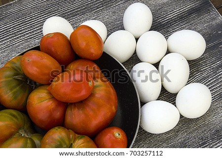 Organic chicken eggs and pictures of natural tomatoes, eggs in tomato pans with baking