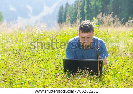 A man working on a laptop outdoors, free space. Businessman working on time for vacation.