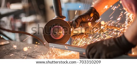 Electric wheel grinding on steel structure in factory. Sparks from the grinding wheel