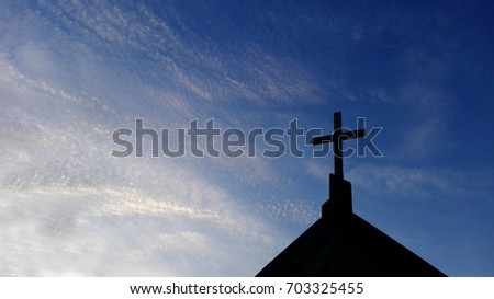 Church Roof  with a cross. Church building roof with holy cross. Cloudy moody sky background. Minimal architecture design and detail. Exterior design and detail. Abstract architecture.