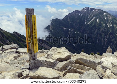 Summit marker on Mount Karamatsu translated into saying you are on the top and elevation of mountain, Northern Alps, Japan