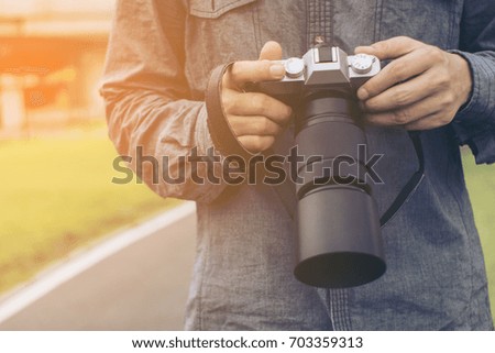 Close-up of a black photo camera.Professional photographer concentrate and continue his passion for photography. selective focus