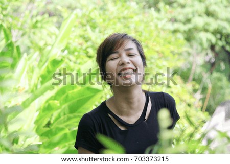 portrait of beautiful young woman wear black t-shirt with happy smile in park, big smile, emotion