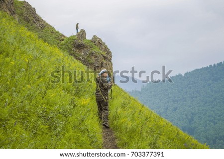 The photographer goes on trail in mountains