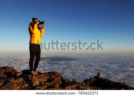 Young girl taking photos on Pico volcano (2531m), Pico Island, Azores, Portugal, Europe