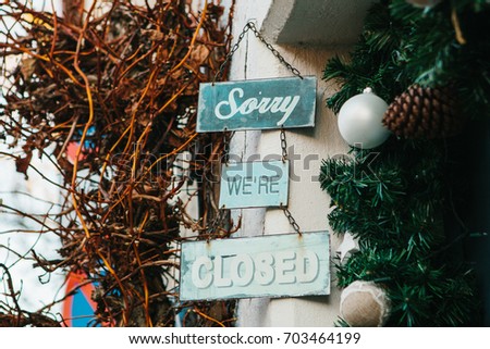 Signboard Sorry we are closed next to the Christmas decorations. The concept of the end of Christmas sales. Conceptual.