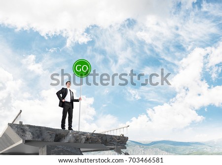 Confident businessman in suit holding green go sign while standing on broken bridge with skyscape and nature view on background. 3D rendering.