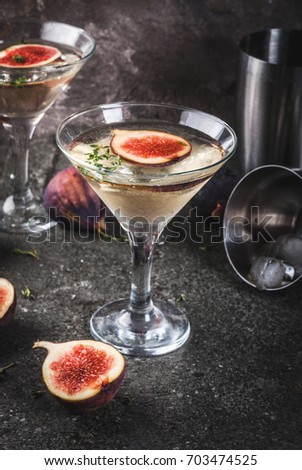 Fall and winter drinks recipes, Martini cocktail with fig, thyme and honey, on black stone table, copy space