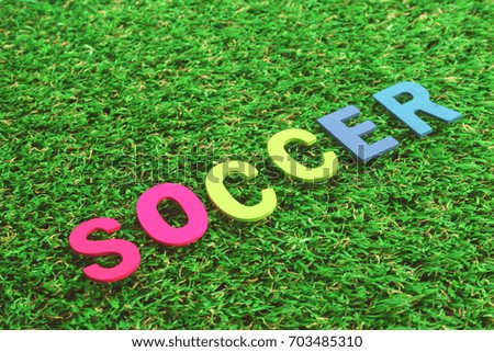 Colorful Wooden Alphabet Word Soccer on green grass background