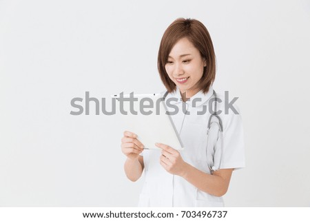 Young attractive asian nurse of the smile,tablet PC