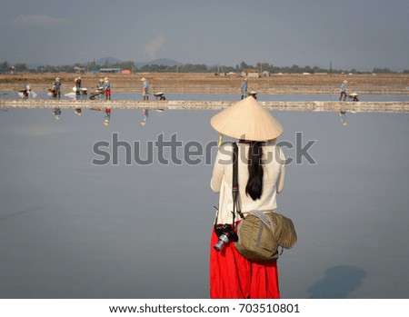 A tourist taking pictures on the salt field in Nha Trang, Vietnam.