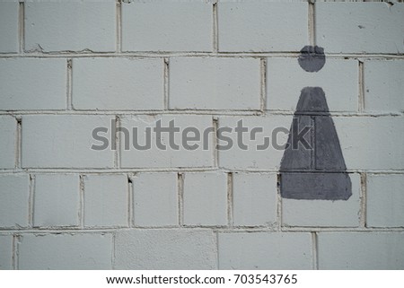 sign of a female toilet on a brick wall