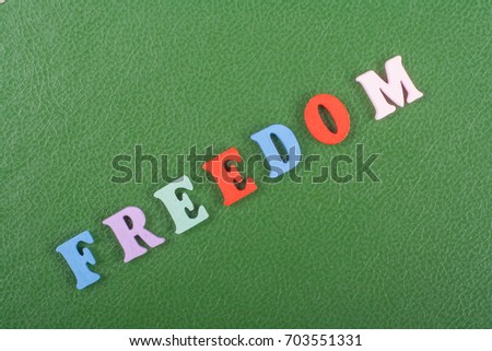 FREEDOM word on green background composed from colorful abc alphabet block wooden letters, copy space for ad text. Learning english concept