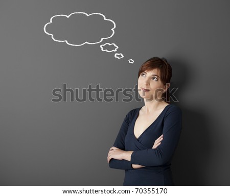 Young woman thinking with a thought a balloon drawn with chalk on the wall