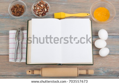 Recipe cook blank book on wooden background, spoon, rolling pin, checkered tablecloth.