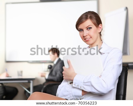 young and attractive businesswoman in an office with colleagues on the background