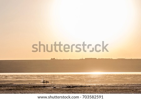 Journey through the lake on a homemade wooden sail raft at sunset