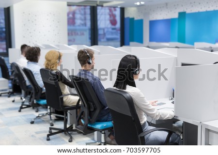 group of young business people with headset working and giving support to customers in a call center office Royalty-Free Stock Photo #703597705