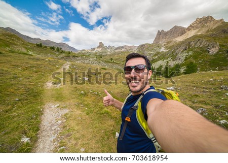 selfie of smiling and excited Mountain Climbers in colored t-shirt with high Peaks on Background