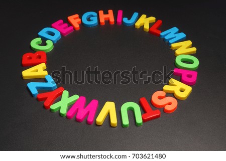 Colored plastic letters on black background. Alphabet.