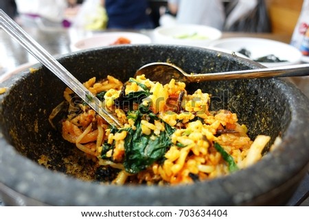 Korean traditional food, close up picture, cooking in a rock bowl wit spoon and fork, 