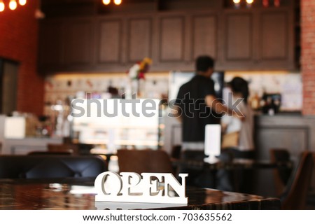 woodcraft in Open letter sign board stand and blurred in coffee shop