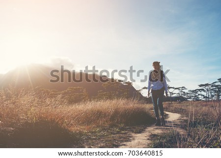 Hikers women walking through a meadow on mountain with sunrise