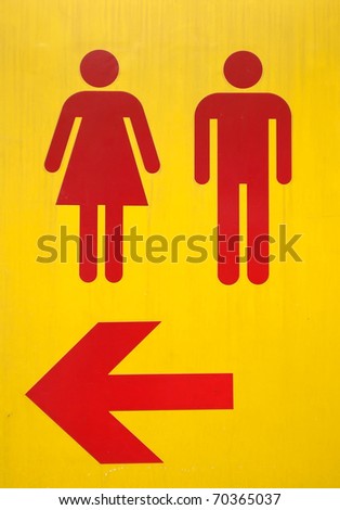 Yellow signs to the toilet with red arrow and symbol of male and female form