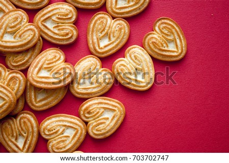 Home made heart shaped cookies for Valentine's Day on red background. Top view with copy space.