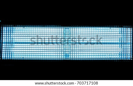 Blue metal mesh with a square pattern on a bright lamp with gradient effect on a black background as horizontal line, close-up of movie illuminant, model the motion of electrons,