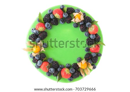 Birthday cake in green glaze, decorated with strawberries, blueberries and blackberry on white background. Picture for a menu or a confectionery catalog. Top view. isolated.