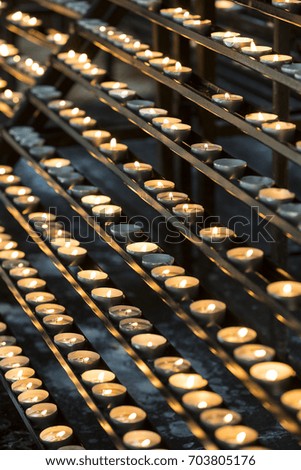 Candles in the church burn on a dark background