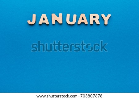 Word January made of wooden letters on blue background.Month planning, timetable concept
