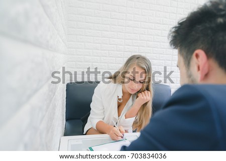 Professional businessman and businesswoman discussing together in the office, businesswoman signing on document, business concept
