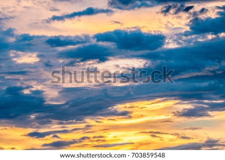 Abstract blurred background, dark cumulonimbus and stormy clouds, colorful dramatic sky with sunlight breaking through dark clouds in twilight. Looks like a watercolor background.