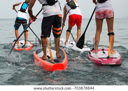 Stand up paddle group on the sea Royalty-Free Stock Photo #703878844