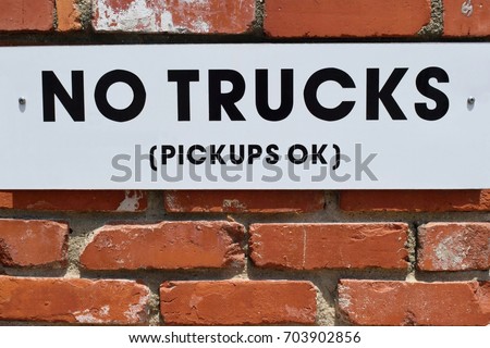 No trucks, white sign on the brick wall, forbidden parking for trucks
