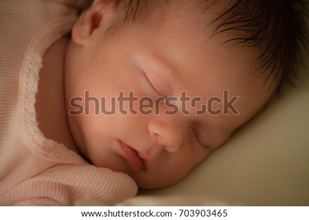 Newborn. Baby girl sleeping. Two weeks old. Close-up.