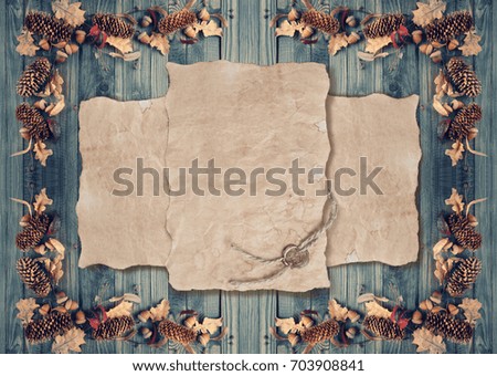 Autumn background with old parchment, acorns, fir cones and dry oak leaves on wooden boards. Copy space. Empty place for photo or text.