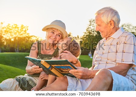 Girl kissing her grandma. Seniors with grandchild, photo album. Living in the good times.