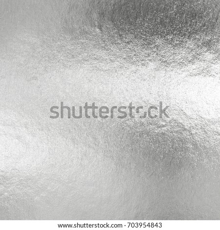 Silver foil shiny metallic texture background wrapping paper for Christmas and winter holiday wallpaper decoration element  Royalty-Free Stock Photo #703954843