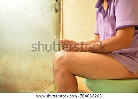 Men play smartphones in the bathroom.