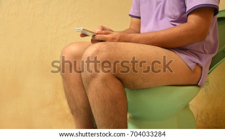 Men play smartphones in the bathroom.