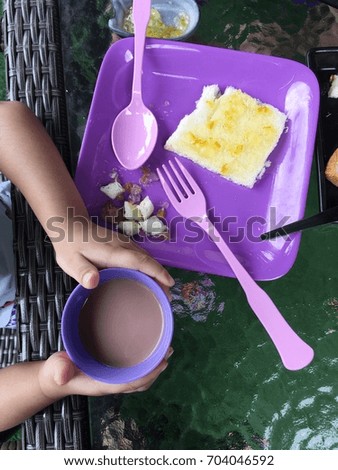 a cup of chocolate milk and bread on a dish.
