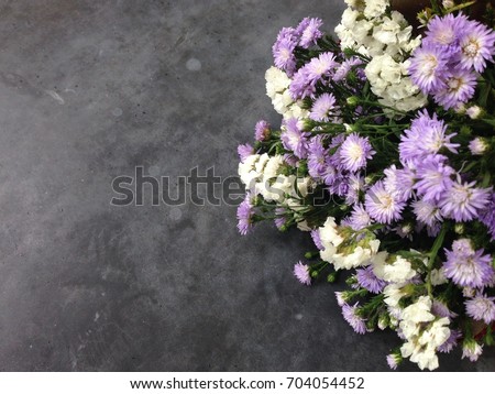Vintage bouquet of colorful flower on the cement floor,purple and white flowers.