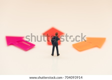 Miniature people: Businessman standing in front of arrow pathway choice using as Business decision concept.
