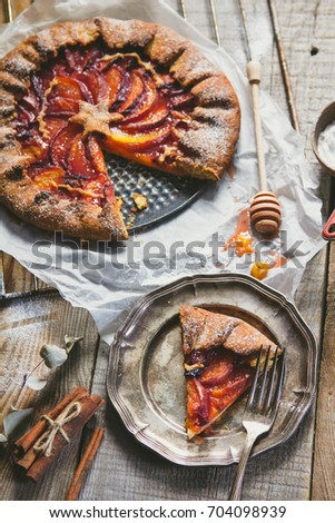 Galette with peaches on the old wooden background. Beautiful sweet cake background