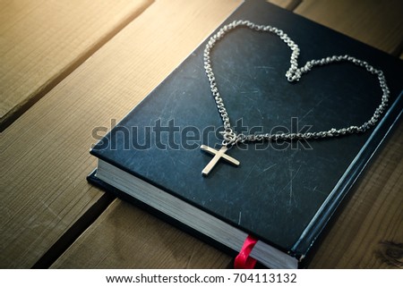 the cross necklace on old holy bible